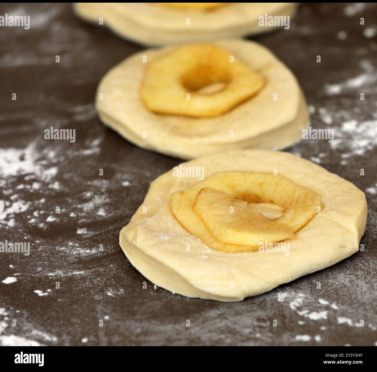 La pomme sonne sur une planche avant la cuisson Banque D'Images
