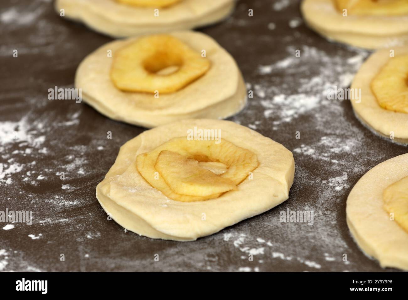 La pomme sonne sur une planche avant la cuisson Banque D'Images