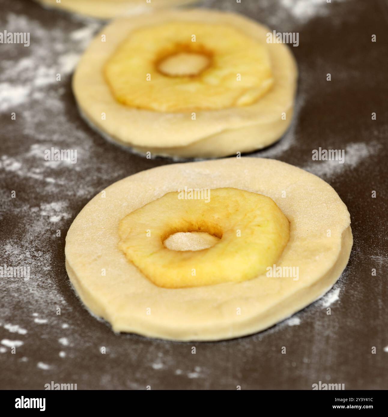 La pomme sonne sur une planche avant la cuisson Banque D'Images