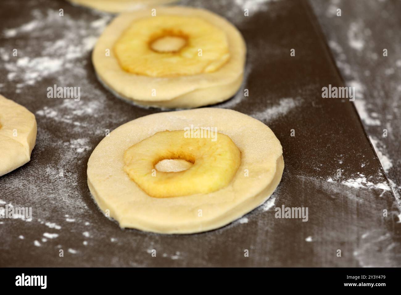 La pomme sonne sur une planche avant la cuisson Banque D'Images