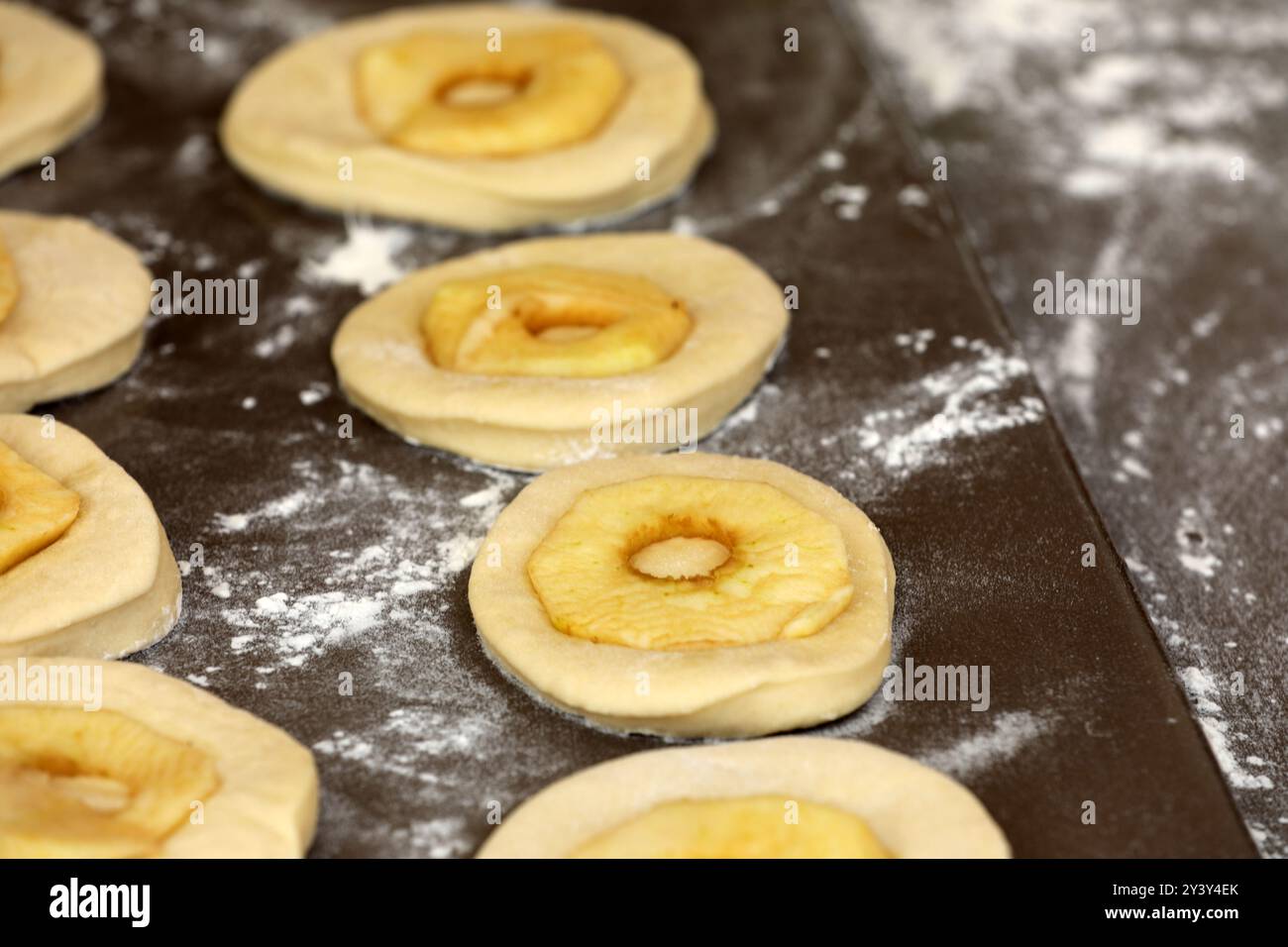 La pomme sonne sur une planche avant la cuisson Banque D'Images