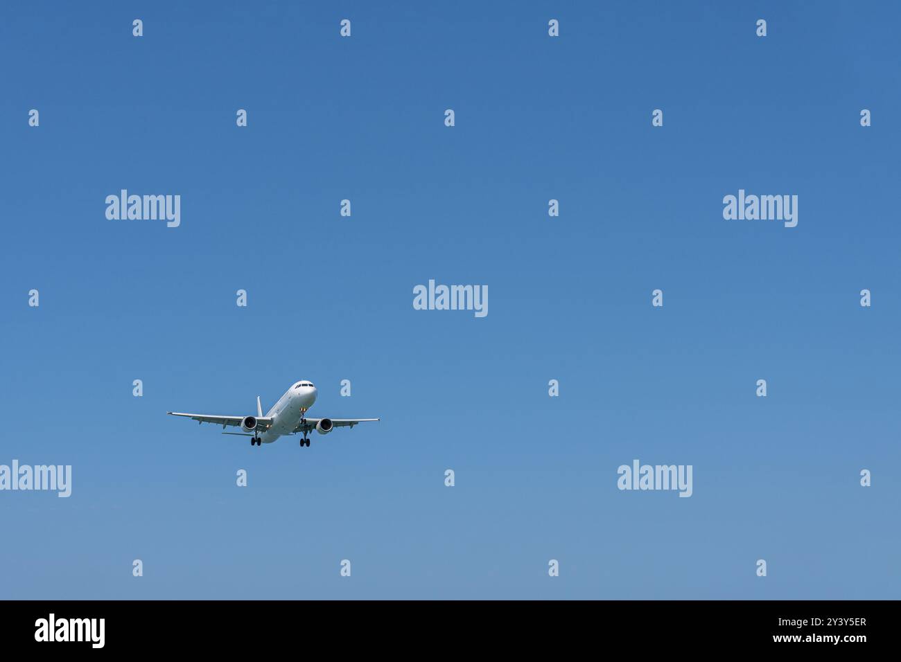 Un avion qui approche dans le ciel bleu vide. Banque D'Images