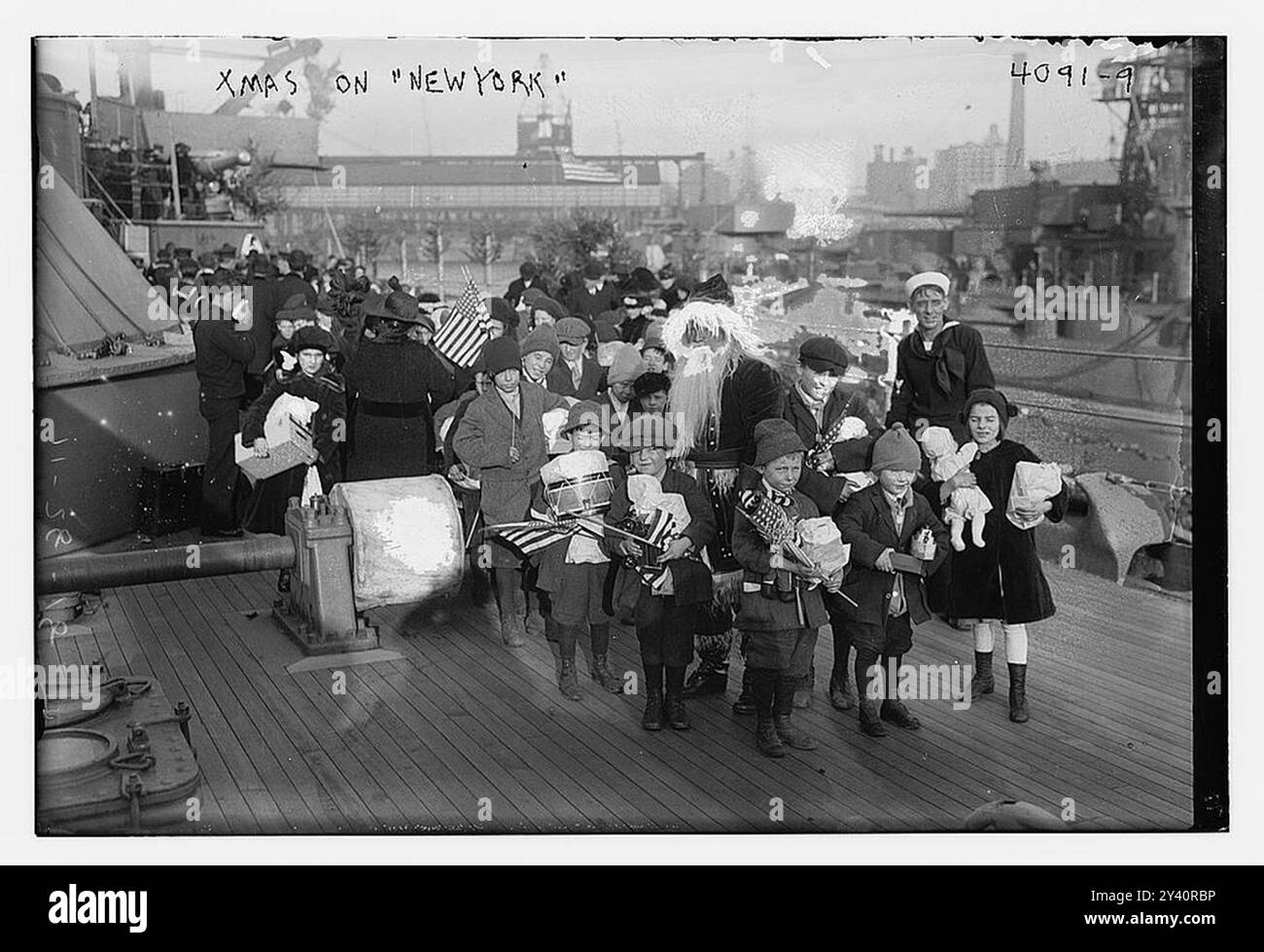 La photographie montre un groupe d'enfants à bord du cuirassé américain 'New York', l'un des plus récents de la flotte nationale, saluant 'Santa Claus Luddy, le compagnon du Bosun le jour de Noël, 1916. Banque D'Images