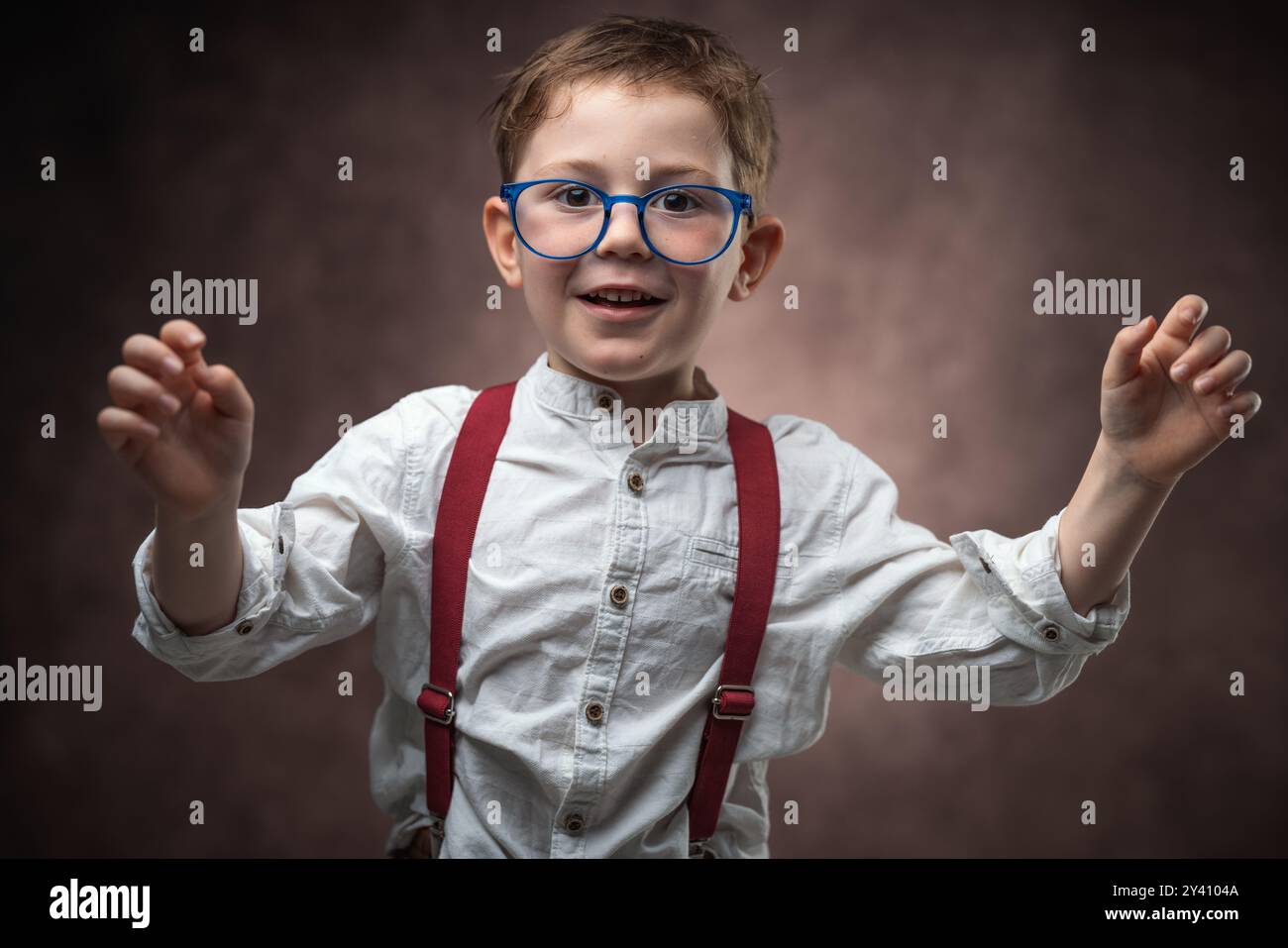 Portrait d'enfant intelligent avec des lunettes habillées de vêtements vintage souriant contre la caméra, écolier, étudiant à l'école Banque D'Images