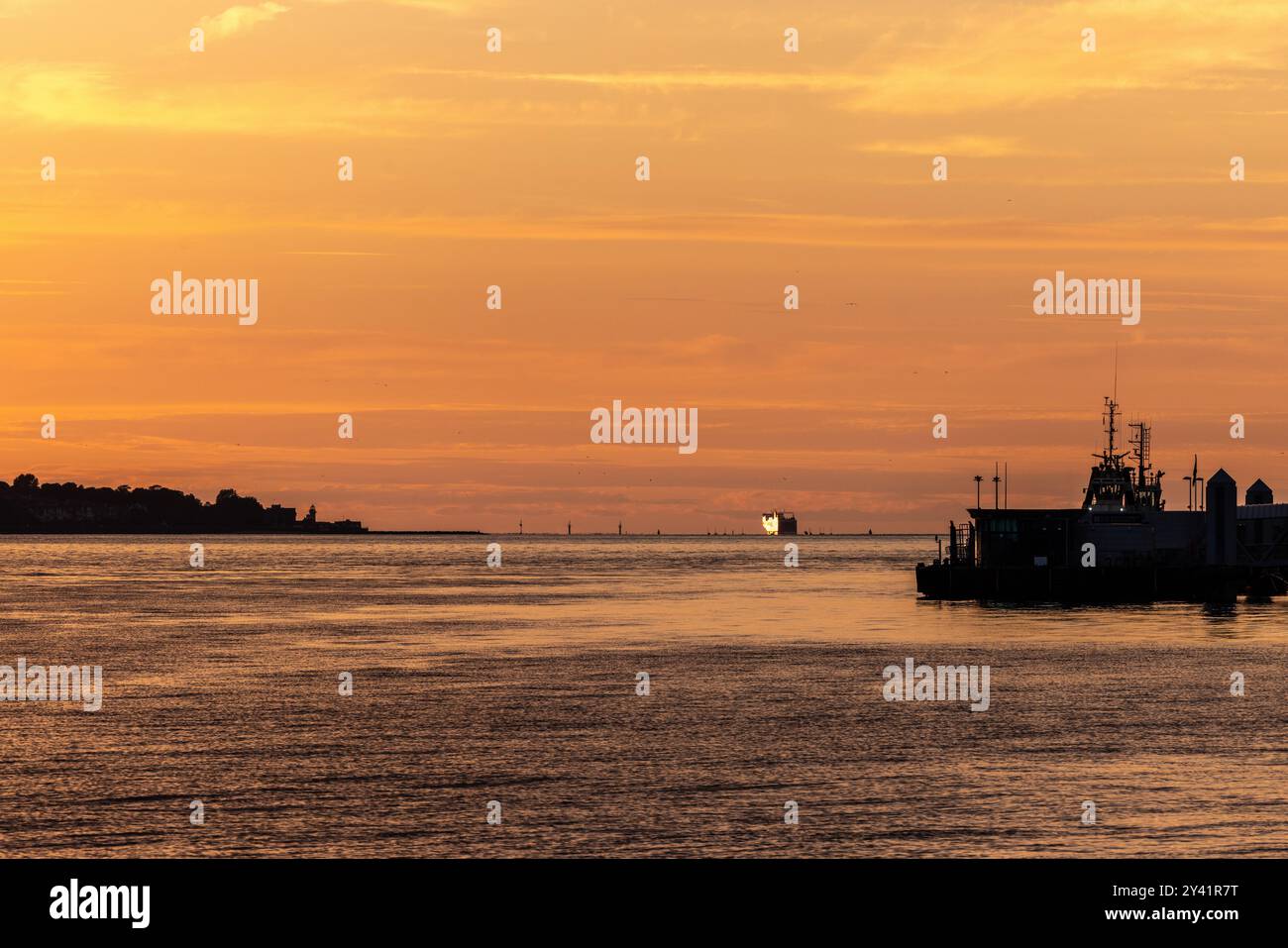 Un bateau sort de l'embouchure de la rivière Mersey au coucher du soleil Banque D'Images
