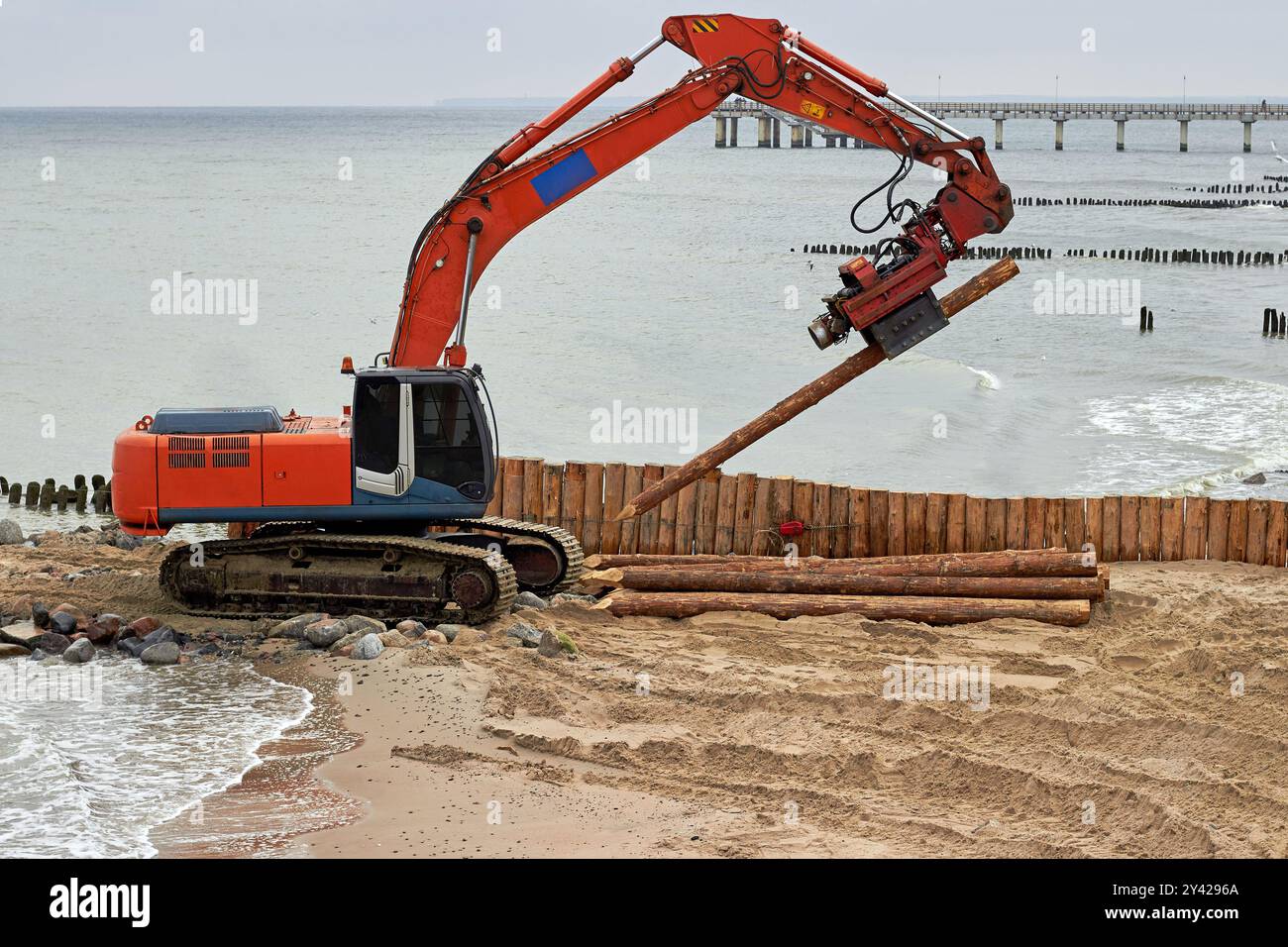 Machine pour enfoncer des pieux au bord de la mer. Travaux sur le renforcement du littoral. Conduite de brise-lames en bois Banque D'Images