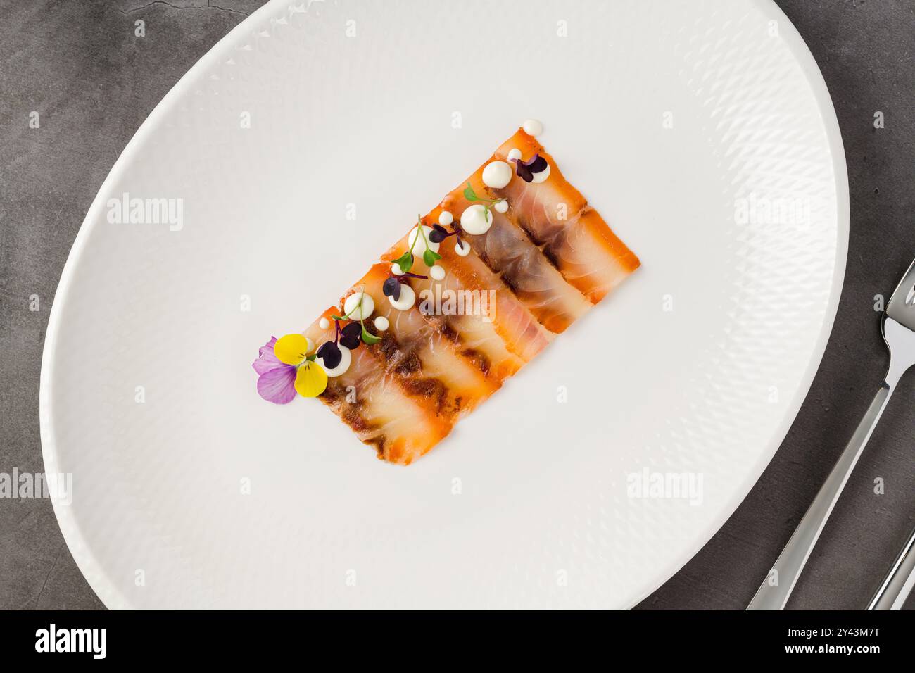 Pastrami de poisson fumé ou bacon sur une assiette en porcelaine blanche Banque D'Images