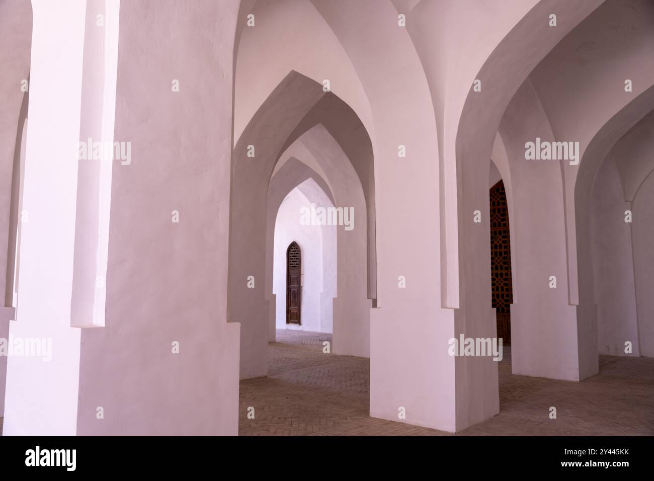 Un couloir long et étroit avec des arches blanches de chaque côté Banque D'Images