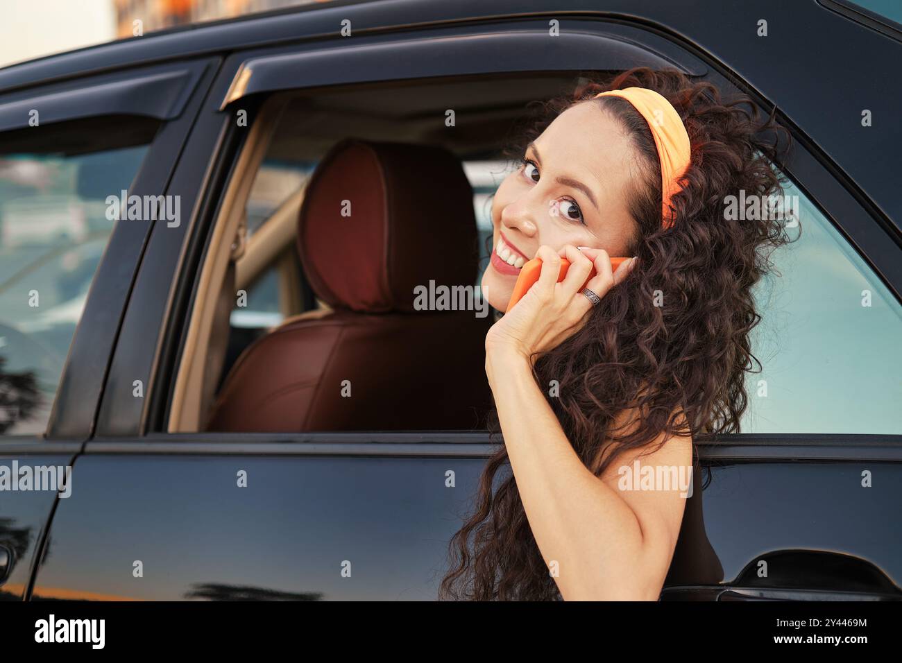 Dame au téléphone dans la voiture pendant le coucher du soleil Banque D'Images