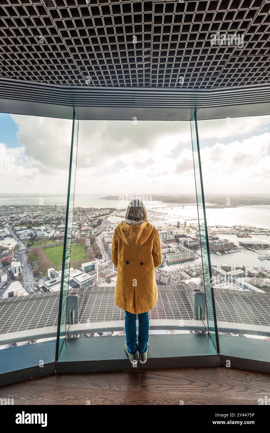 Fille regardant par la fenêtre d'observation au-dessus d'Auckland Nouvelle-Zélande Banque D'Images