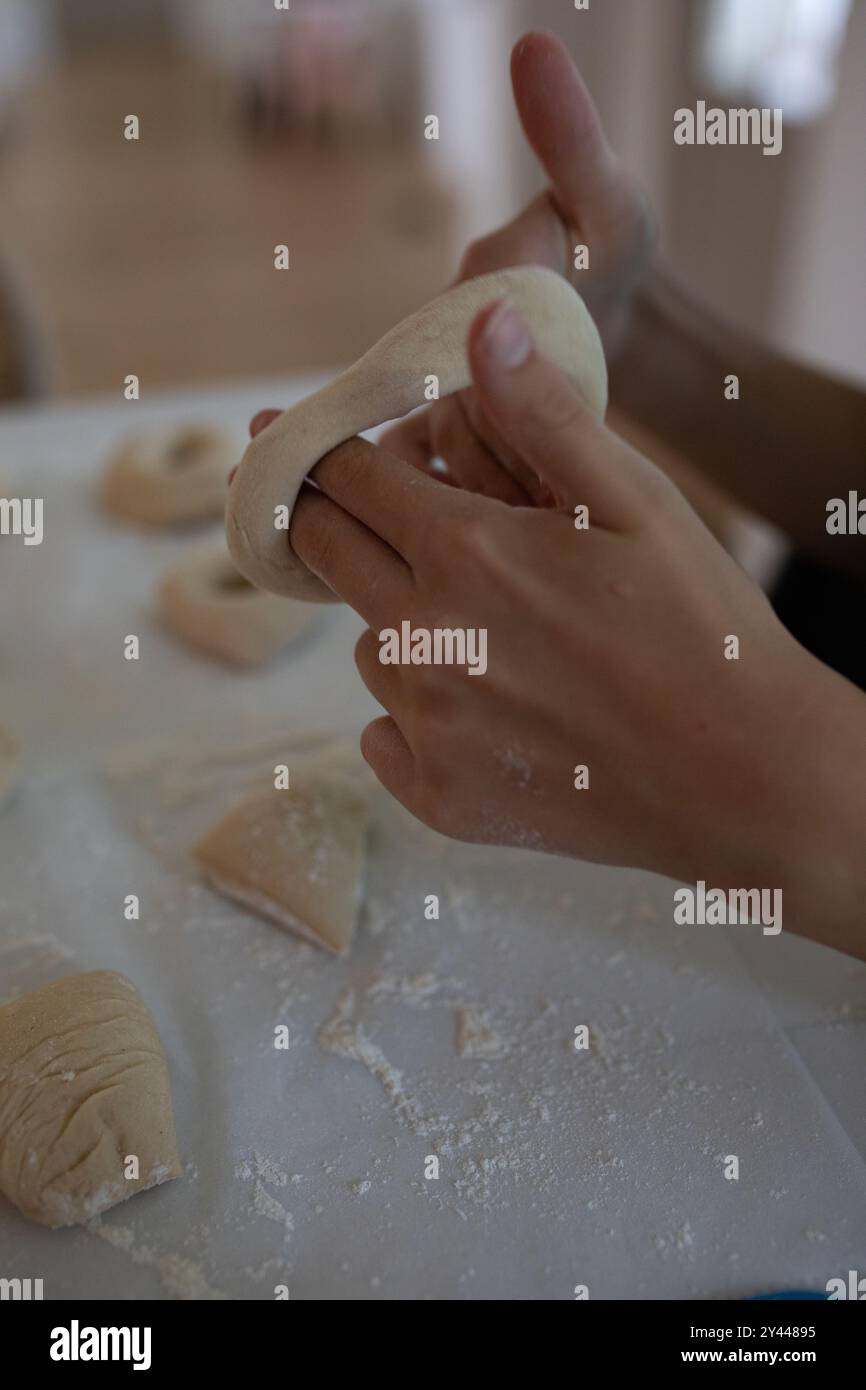 Fabrication de bagels artisanaux : un gros plan sur la mise en forme de la pâte Banque D'Images