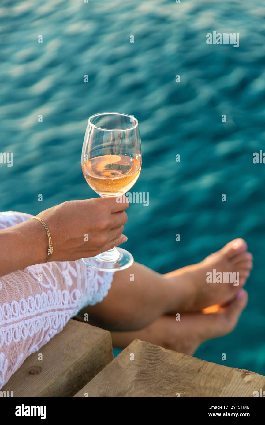 Vin dans un verre sur le bord de mer. Mise au point sélective. Voyage. Banque D'Images