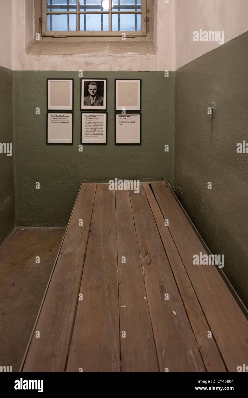 Intérieur d'une petite cellule de détention dans le 'Bunker' du camp de concentration Buchenwald avec lit et portrait et noms des victimes Banque D'Images