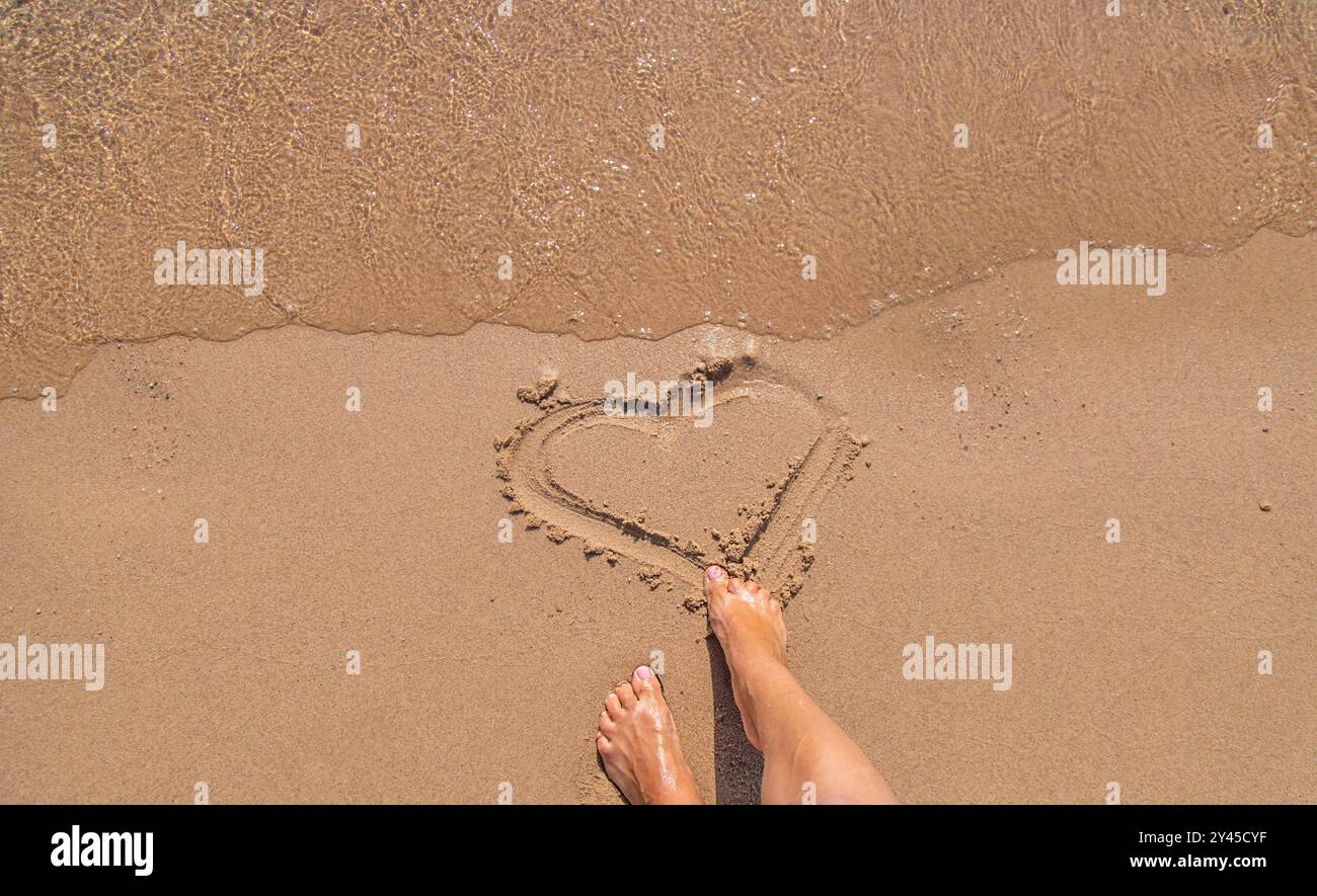 Les pieds de la femme sur le sable à la mer. Mise au point sélective. nature. Banque D'Images