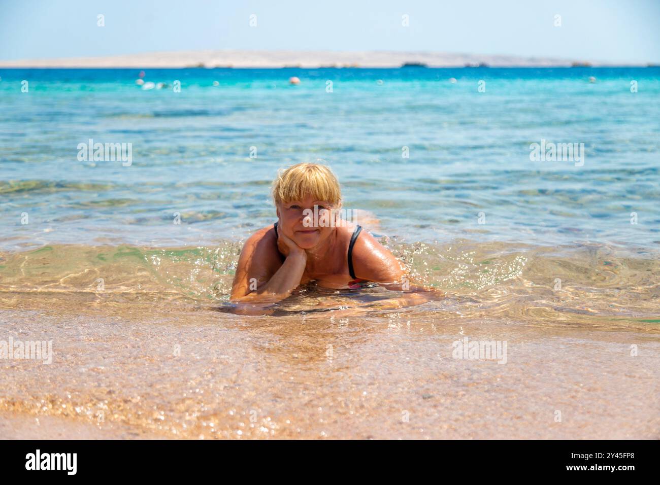 Femme se relaxant sur la plage dans la mer. Mise au point sélective. voyage. Banque D'Images