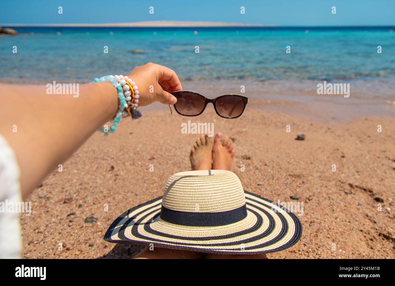 Lunettes de soleil dans les mains en mer. Mise au point sélective. Nature. Banque D'Images