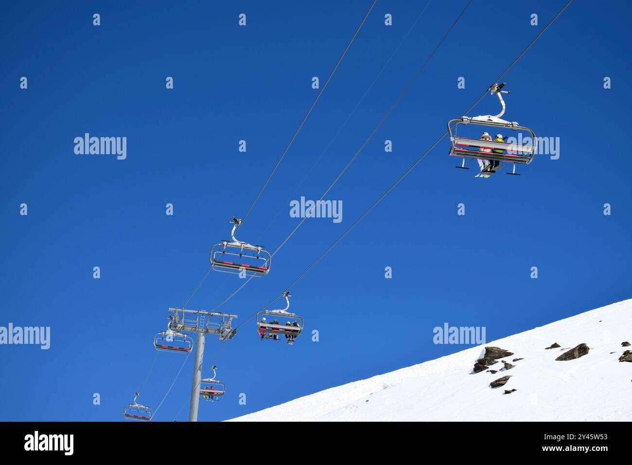 Télésièges pour skieurs et snowboarders par une journée claire et ensoleillée dans une station de ski française Banque D'Images