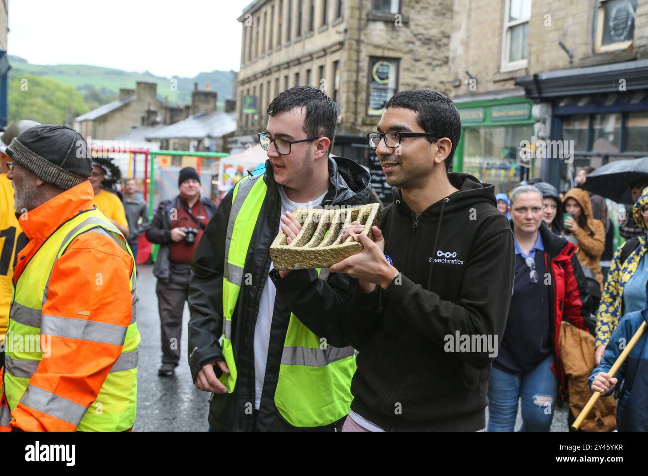 8 septembre 2024. Ramsbottom, Bury, Lancashire, Royaume-Uni. Les championnats du monde de lancer de pudding noir. Les concurrents se tiennent sur une «grille dorée» qui est cérémoniellement défilé sur Bridge Street, dans le village de Ramsbottom, et placé à la porte de la maison publique Oaks. Les concurrents se tiennent debout avec un pied sur la grille, et avec un 'lob' sous les bras lancer 3 puddings noirs faits par Chadwicks de Bury à 12 puddings Yorkshire sur un socle de 30 pieds / 6 mètres sur un échafaudage. Le sport signifie l'emnity/rivalité entre les comtés anglais voisins du Lancashire et du Yorkshire datant de la Guerre du Banque D'Images