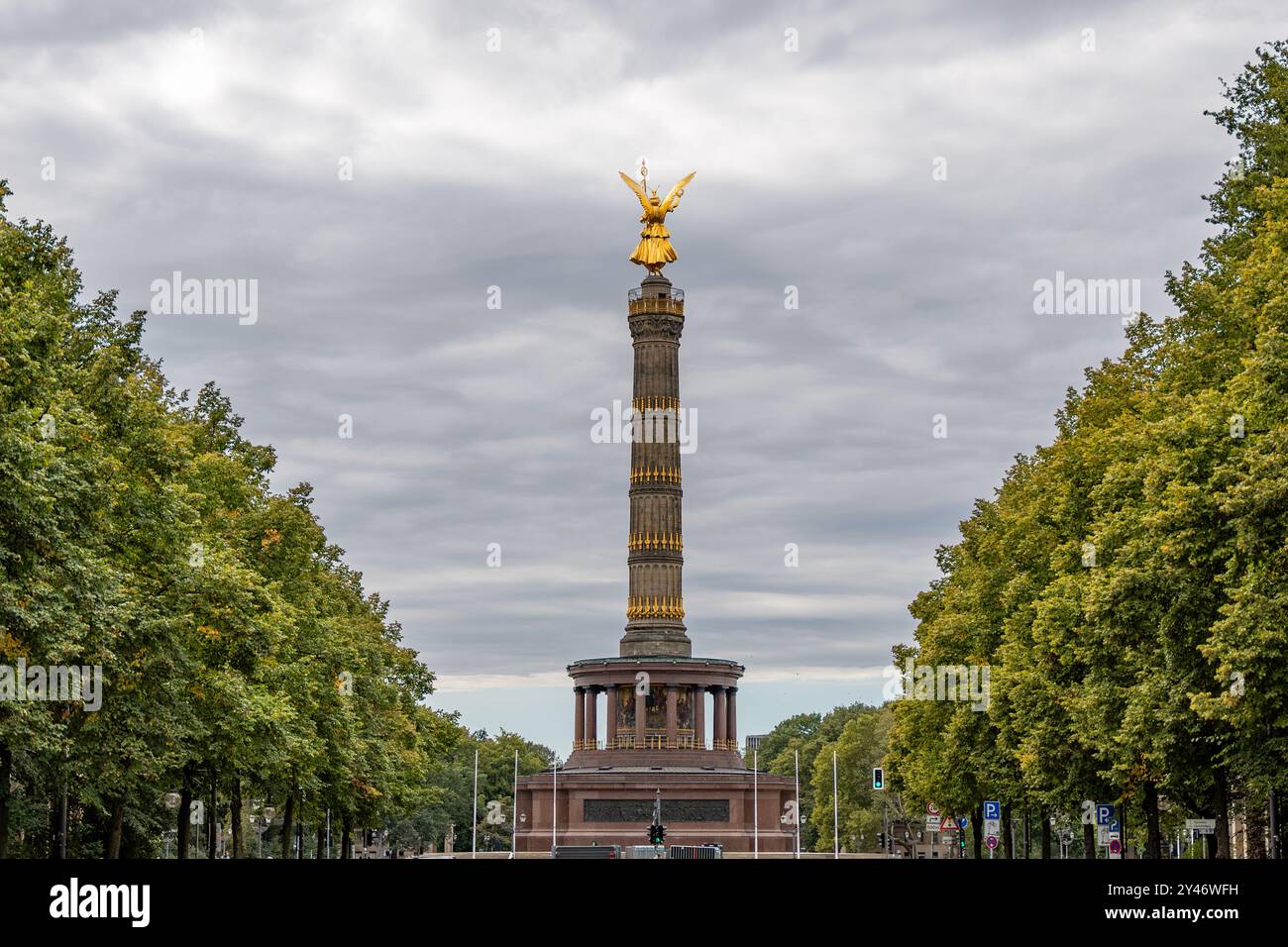 Une grande colonne ornée avec une statue sur le dessus. La colonne est entourée d'arbres et est située dans un parc ou une zone publique. La scène est pleine de grandeur A. Banque D'Images