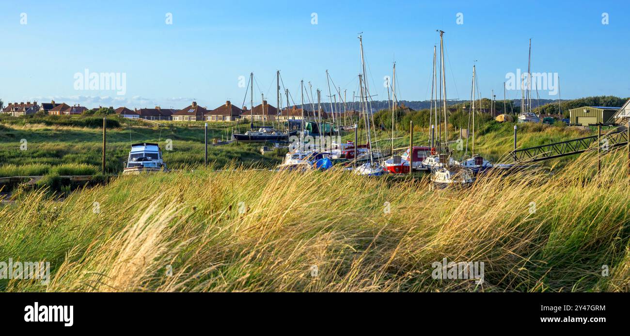 Bateaux dans le quai à l'estuaire de la rivière Exe à Uphill, Weston-Super-Mare, Royaume-Uni le soir d'été à l'heure dorée avec le ciel bleu Banque D'Images