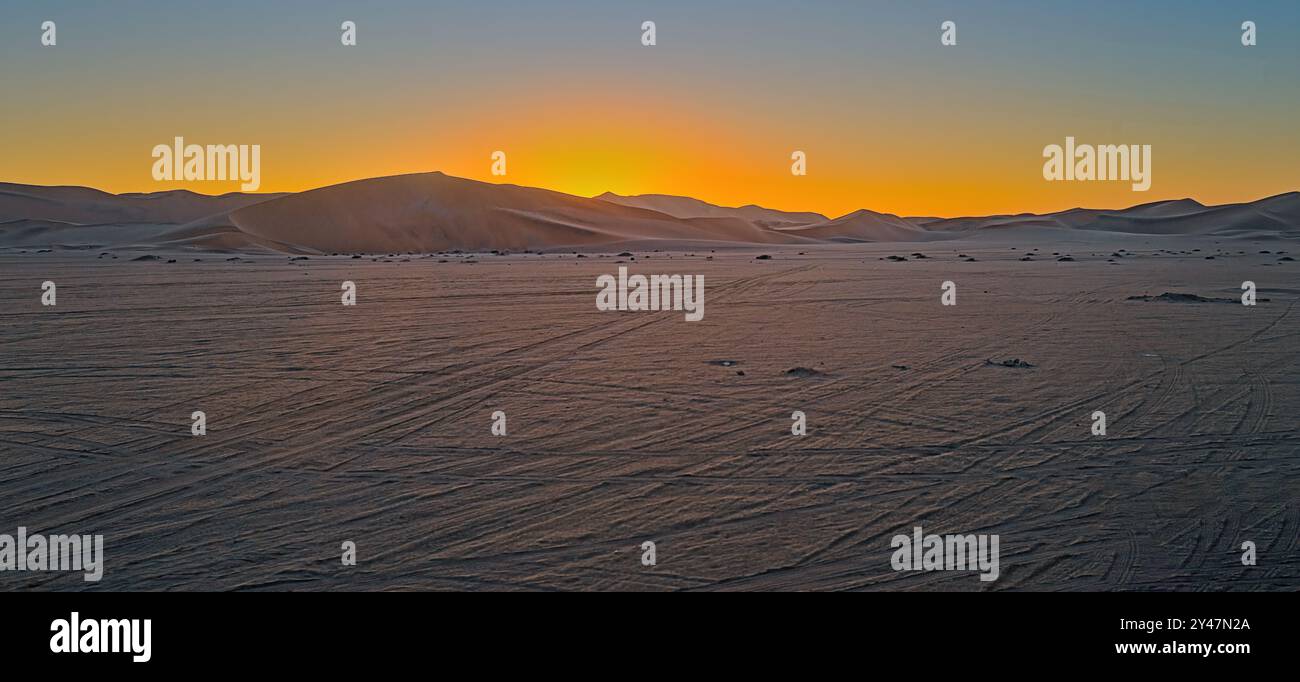 Le soleil coule sous les dunes de sable en Namibie. Banque D'Images