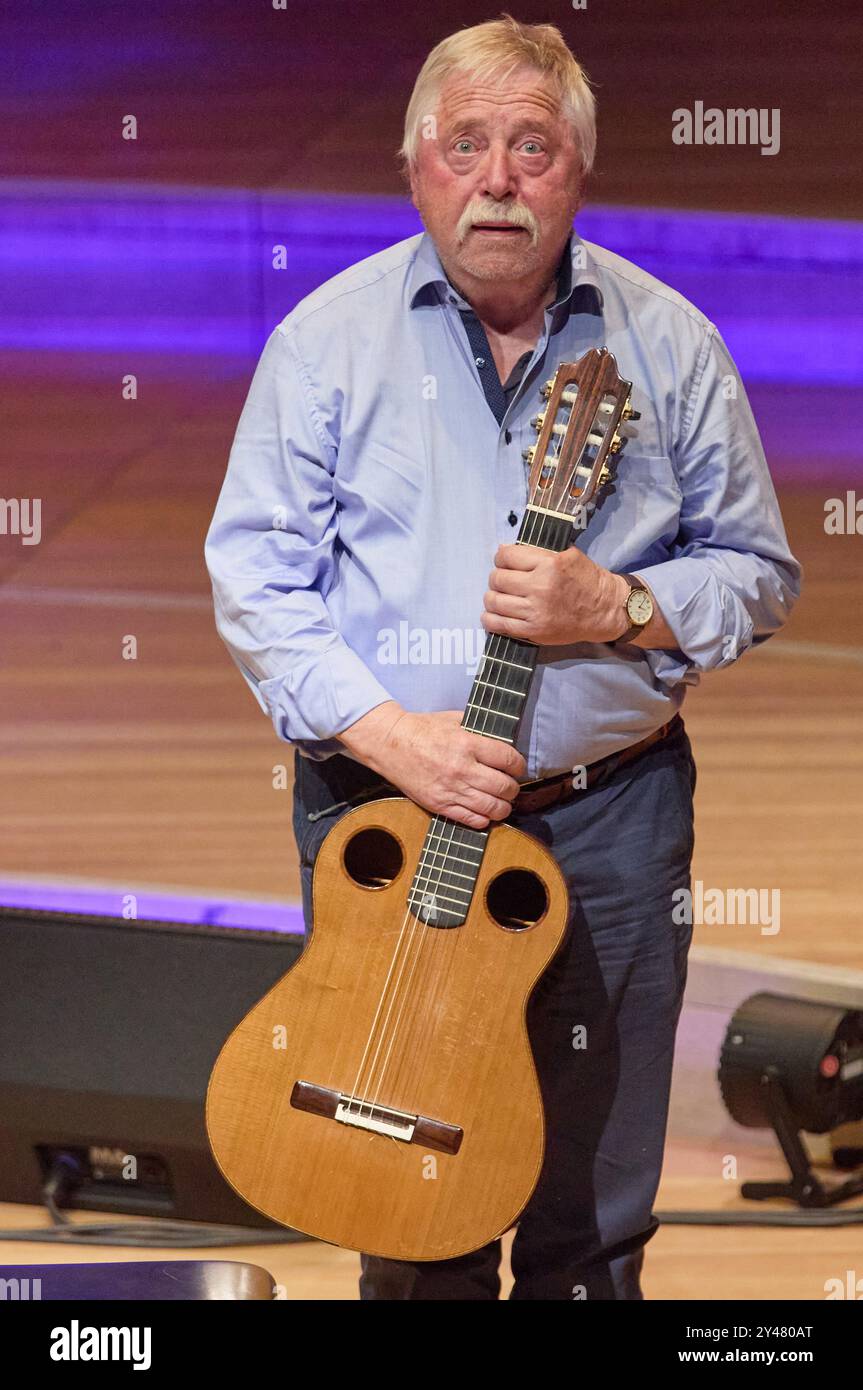 Hambourg, Allemagne. 16 septembre 2024. Wolf Biermann, auteur-compositeur-interprète et parolier, se tient sur scène avec une guitare dans les mains lors du concert de solidarité "appel à l'humanité" dans la salle de concert Elbphilharmonie. Avec le concert initié par le pianiste Levit, de nombreuses célébrités veulent montrer l’exemple contre l’antisémitisme grandissant en Allemagne. Crédit : Georg Wendt/dpa/Alamy Live News Banque D'Images