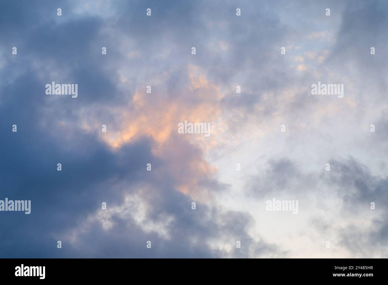 Le ciel est rempli d'un spectacle dramatique de nuages alors que le jour passe en soirée, avec des tons doux d'orange et de bleu mélangeant le beau Banque D'Images