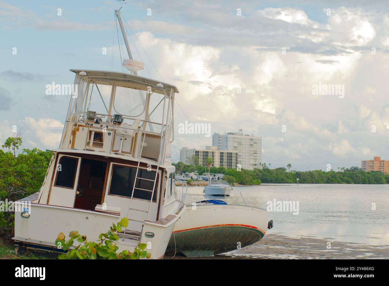 Vue panoramique sur les flaques d'eau à marée basse vers le large bateau de pêche abandonné blanc sur le rivage de Maximo Park Water vers Skyway Channel Banque D'Images