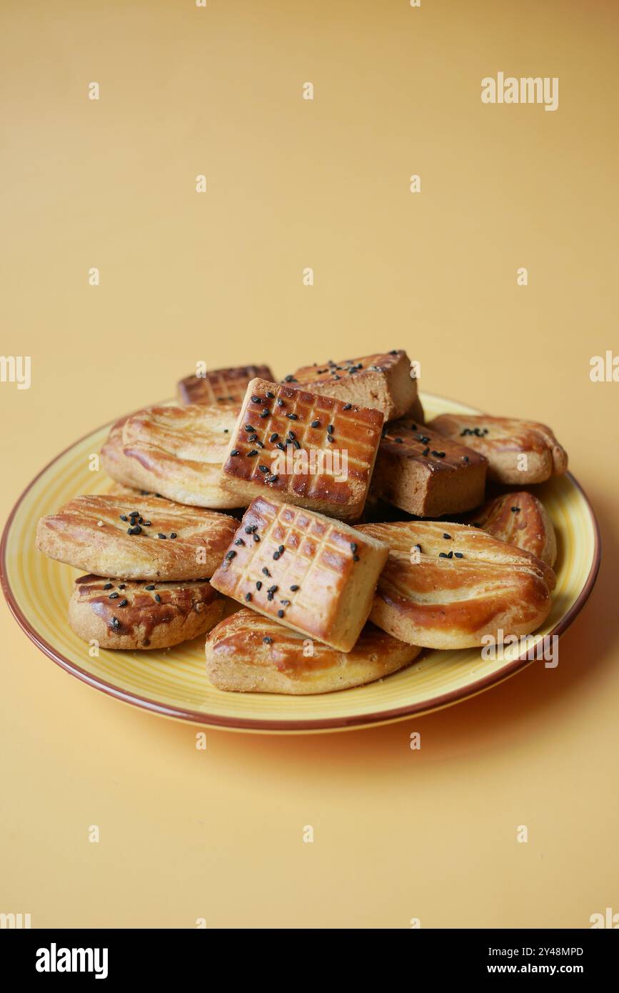 Une variété de délicieuses pâtisseries assorties magnifiquement disposées sur une assiette jaune vibrante Banque D'Images