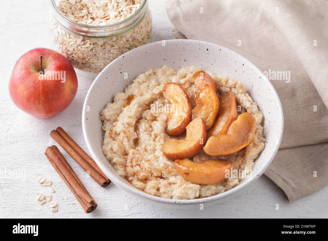 Bouillie d'avoine sucrée avec tranches de pommes cuites au four, cannelle et sauce caramel Banque D'Images