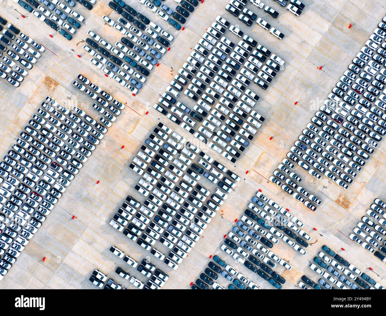 Vue aérienne de la logistique automobile. Parking de l'usine rempli de rangées de voitures neuves. Production et distribution de véhicules modernes. Importer ou exporter Banque D'Images