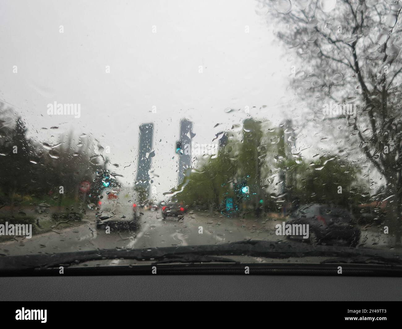 Une photo d'une fenêtre éclaboussée de pluie, révélant un arrière-plan de voiture traficc. Vue des gouttes de pluie sur la fenêtre Banque D'Images