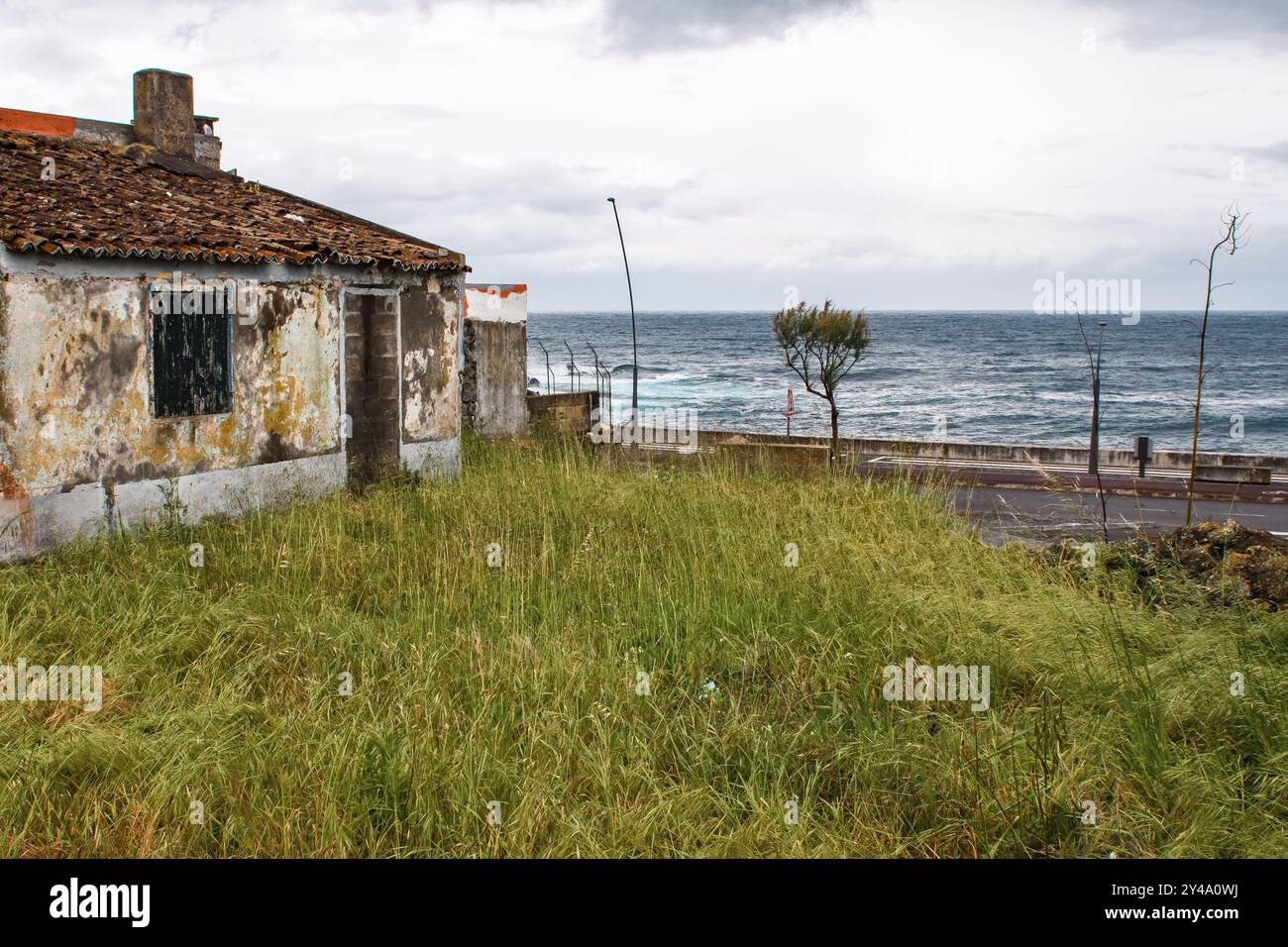 Ponta Delgada, Iles Açores, Portugal - 26 avril 2017 : une maison abandonnée en bord de mer dépassée par la nature. Banque D'Images