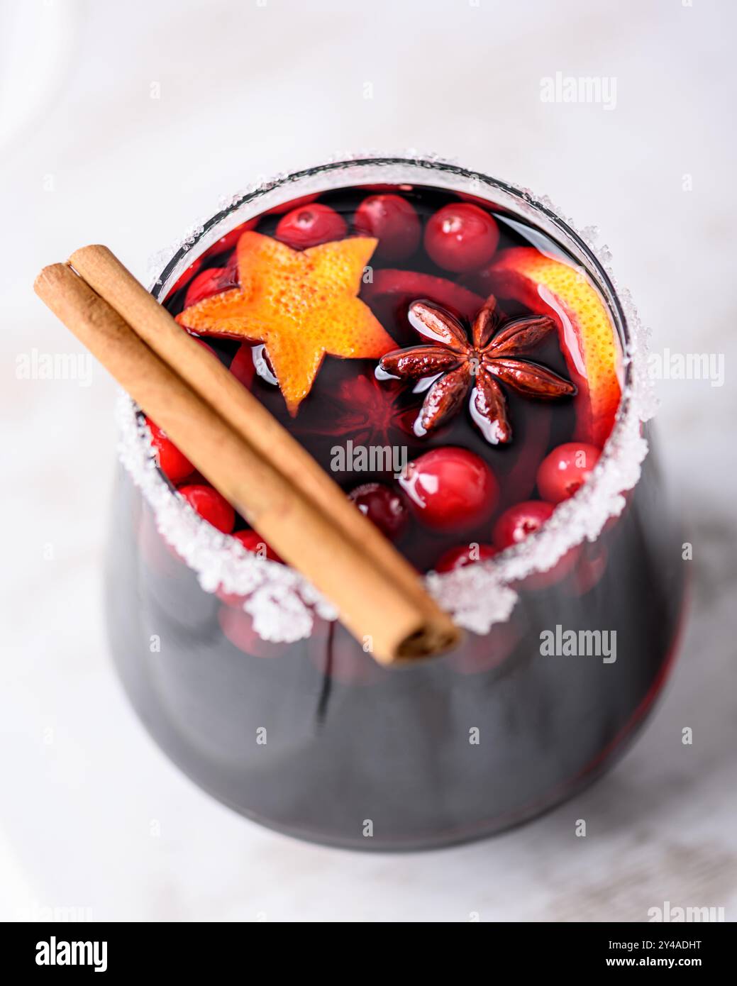 Boisson de Noël - vin chaud épicé rouge en verre avec des tranches d'orange, cannelle, anis étoilé et canneberges Banque D'Images