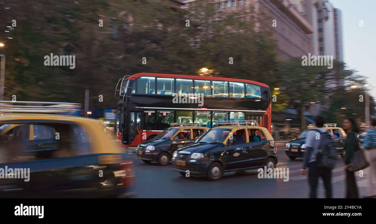 Mumbai, Inde. Bus à impériale avec passagers descend la rue à Mumbai. Crépuscule dans la ville. Motos, voitures et taxis se déplaçant sur la rue dans la soirée Banque D'Images