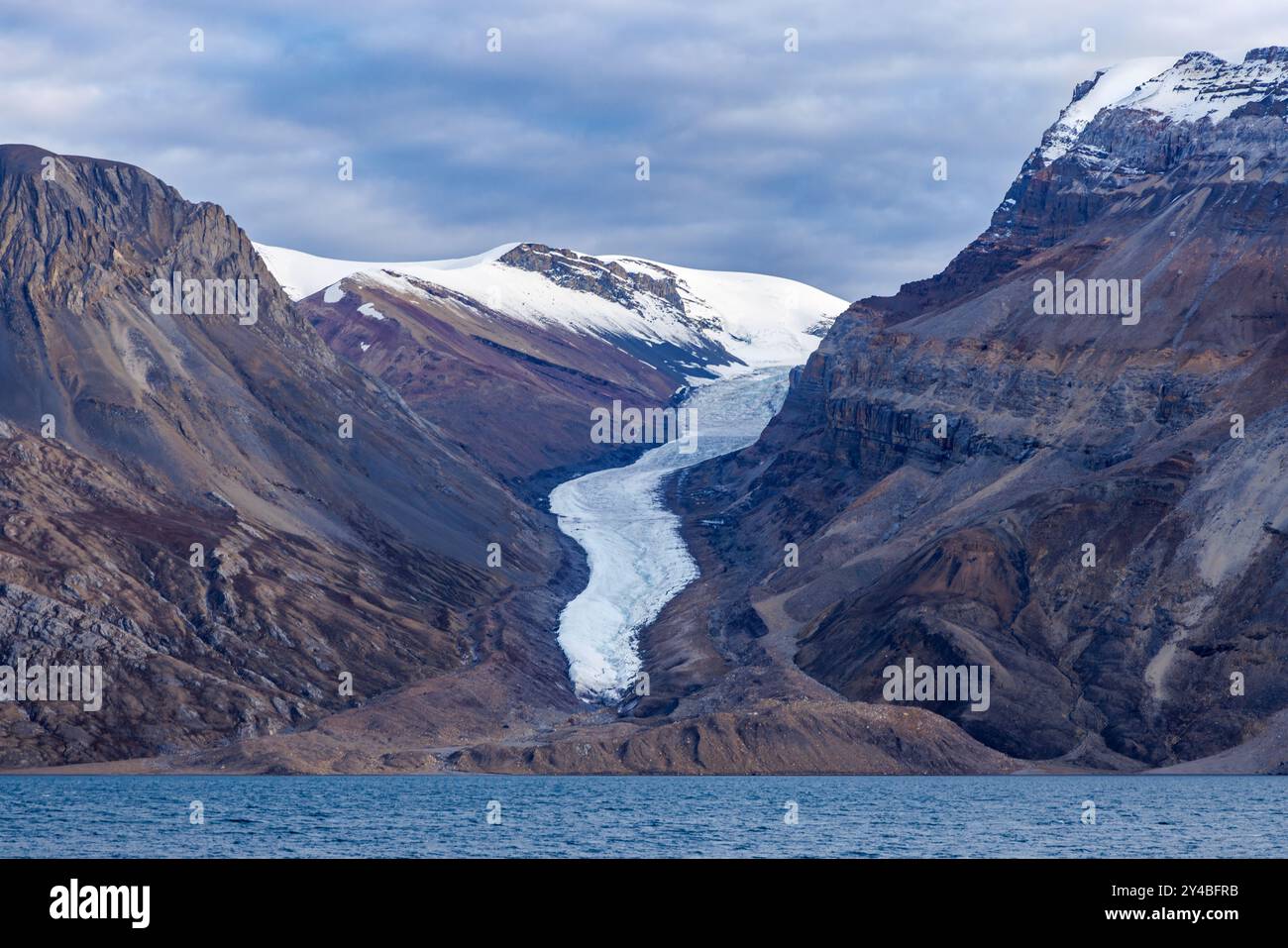 Un glacier suspendu dans les montagnes du Kaiser Franz Joseph Fjord, au nord-est du parc national du Groenland, au crépuscule. Banque D'Images