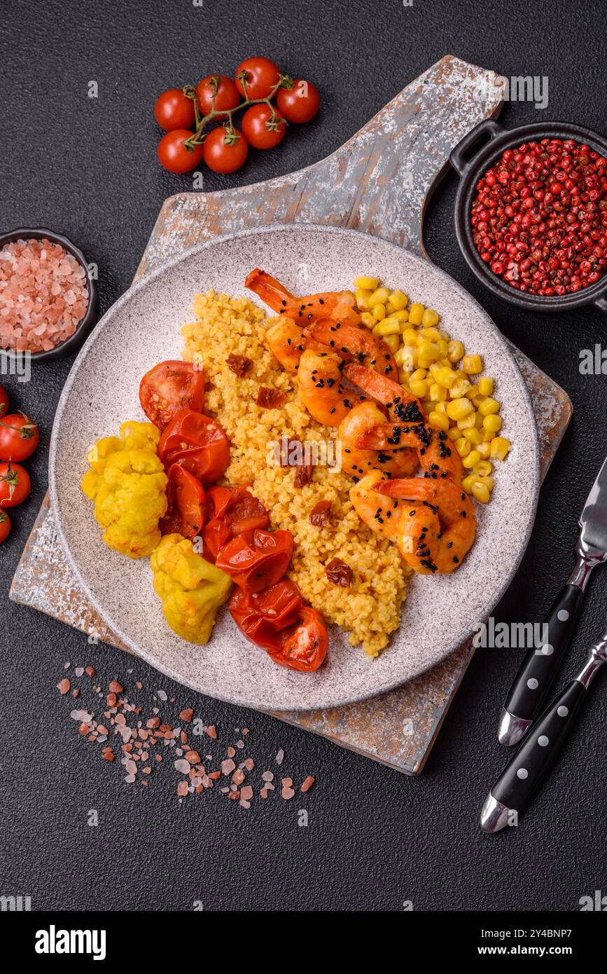 Crevettes tigrées bouillies avec du porridge, des tomates et du maïs sur un fond de béton foncé Banque D'Images