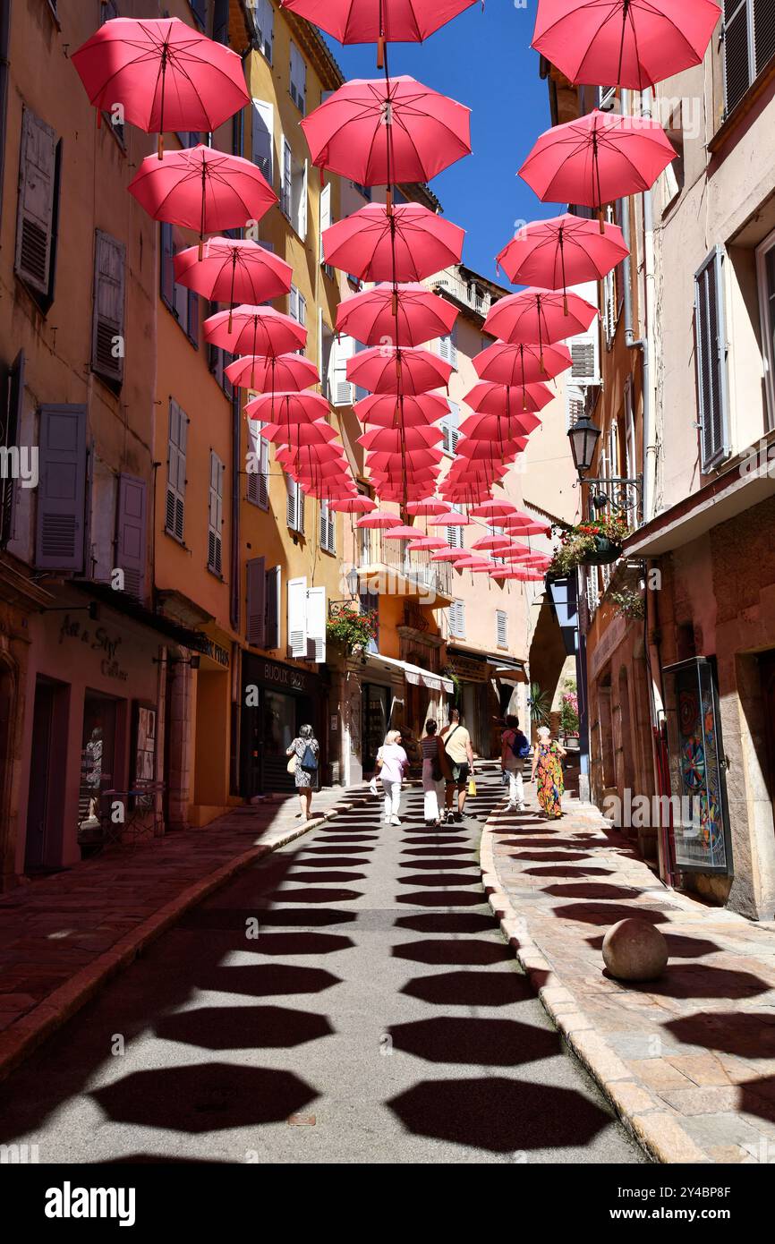 Des parapluies roses décorent les rues de Grasse en France Banque D'Images