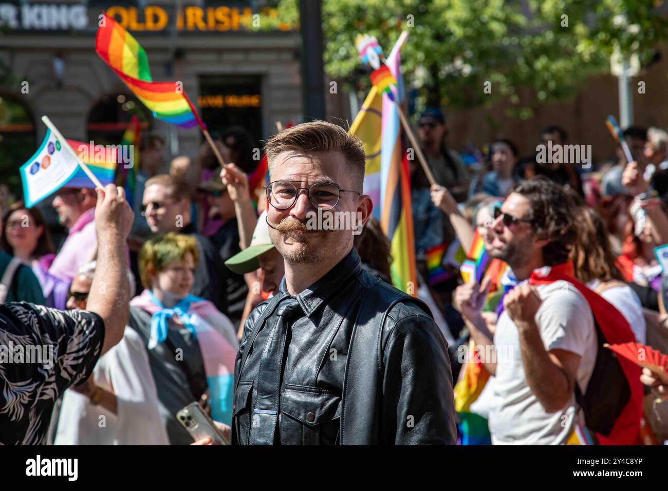 Homme souriant avec une moustache froncée et des vêtements en cuir noir au défilé Helsinki Pride 2024 sur Mannerheimintie à Helsinki, Finlande Banque D'Images
