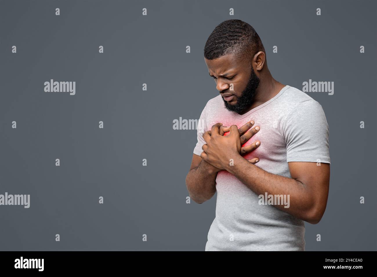 Triste jeune homme afro frottant sa poitrine Banque D'Images