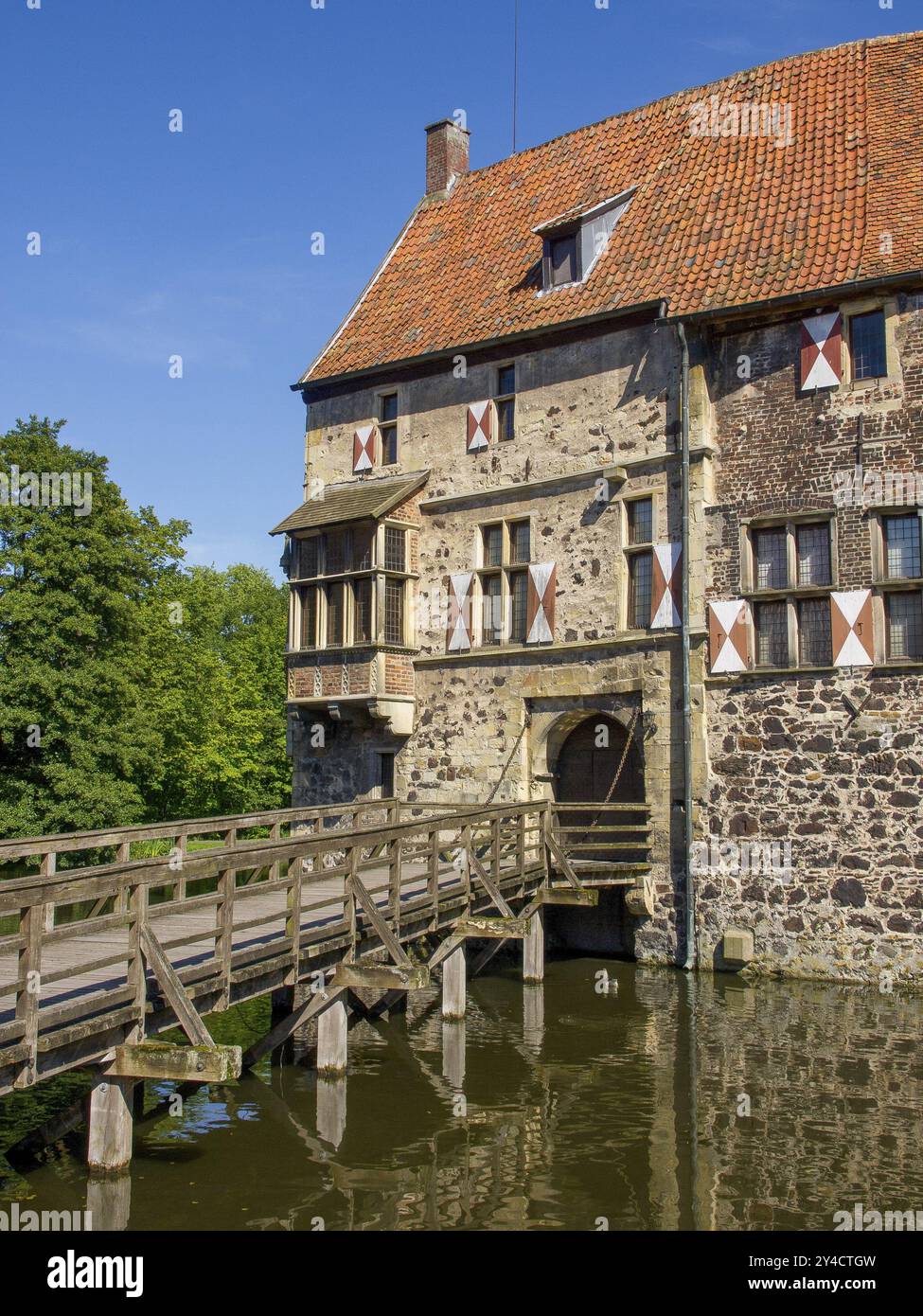 Château médiéval avec volets et pont en bois sur les douves sous le ciel bleu, vischering, luedinghausen, allemagne Banque D'Images