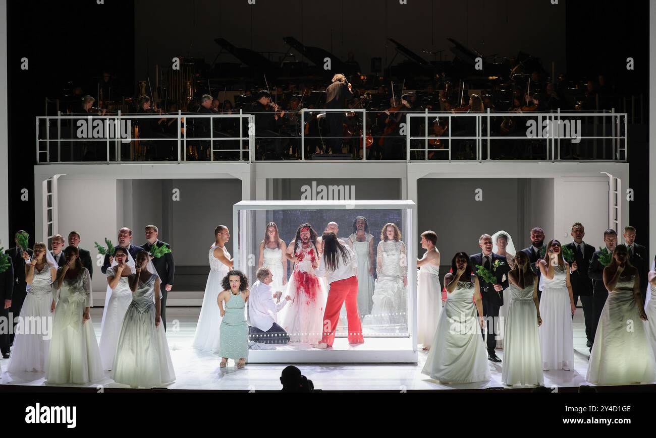 Hambourg, Allemagne. 17 septembre 2024. Oleksiy Palchykov, Cody Quattlebaum et Nicole Chevalier (dans la boîte, gauche-droite), extras, le chœur du Liatoshynski Capella à Kiev (Ukraine) et l'Orchestre philharmonique d'État de Hambourg se tiennent sur la scène de l'Opéra d'État de Hambourg lors d'une répétition photographique de la production 'Trionfi'. L'opéra 'Trionfi' de Carl Orff dans une production de Calixto Bieito et sous la direction musicale de Kent Nagano sera présenté en première sur la scène principale de l'Opéra d'État de Hambourg le 21 septembre 2024. Crédit : Christian Charisius/dpa/Alamy Live News Banque D'Images