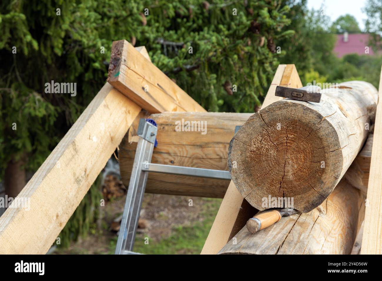 Maison en bois est en construction. Outils de charpentier, chevrons et bûche de poutre de crête, photo en gros plan Banque D'Images