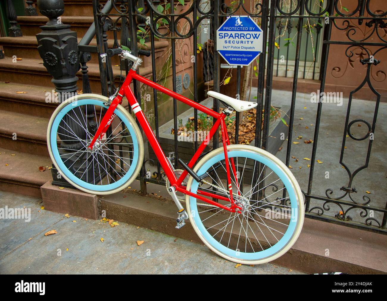 Un vélo coloré verrouillé à une clôture dans le quartier de Clinton Hill à Brooklyn, NY Banque D'Images