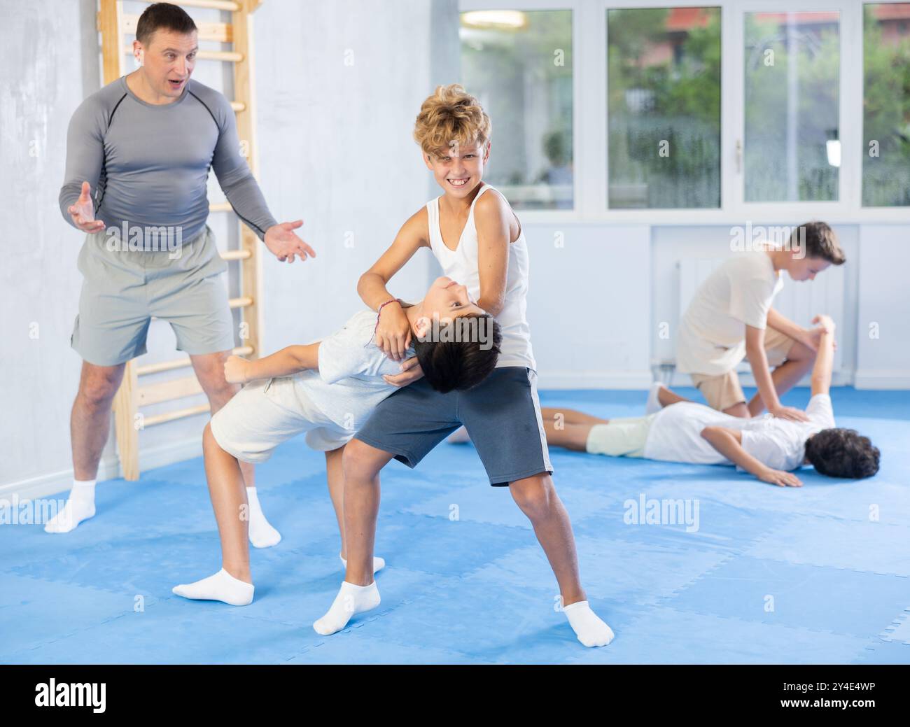 Les adolescents apprennent à faire jeter sur l'épaule dans la leçon d'auto-défense dans la salle de sport Banque D'Images