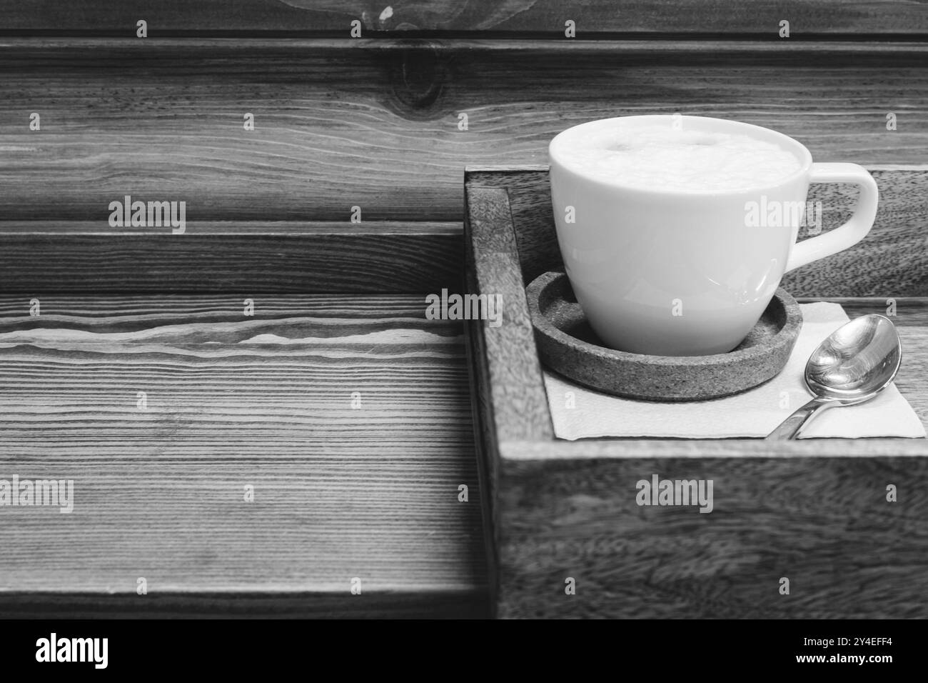 Tasse à café blanche avec cuillère sur plateau en bois, noir et blanc. Americano avec du lait sur le plateau de service, monochrome. Concept de pause-café. Boisson chaude servie Banque D'Images Tasse à café blanche avec cuillère sur plateau en bois, noir et blanc. Americano avec du lait sur le plateau de service, monochrome. Concept de pause-café. Boisson chaude servie Banque D'Images