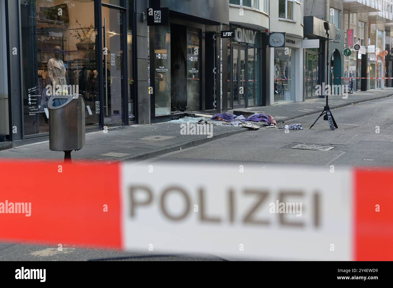 Cologne, Allemagne. 18 septembre 2024. Des éclats et des vêtements se trouvent devant un magasin à Ehrenstraße à Cologne. Il y a eu une autre explosion dans le centre-ville de Cologne tôt mercredi matin. Selon les rapports de police, il y a eu une détonation dans un magasin de vêtements à Ehrenstraße vers 8 h 5,00. Il n'y a pas eu de blessés. Une explosion avait déjà eu lieu lundi dans une discothèque de Cologne, dans laquelle un homme de 53 ans avait été légèrement blessé. Crédit : Henning Kaiser/dpa/Alamy Live News Banque D'Images