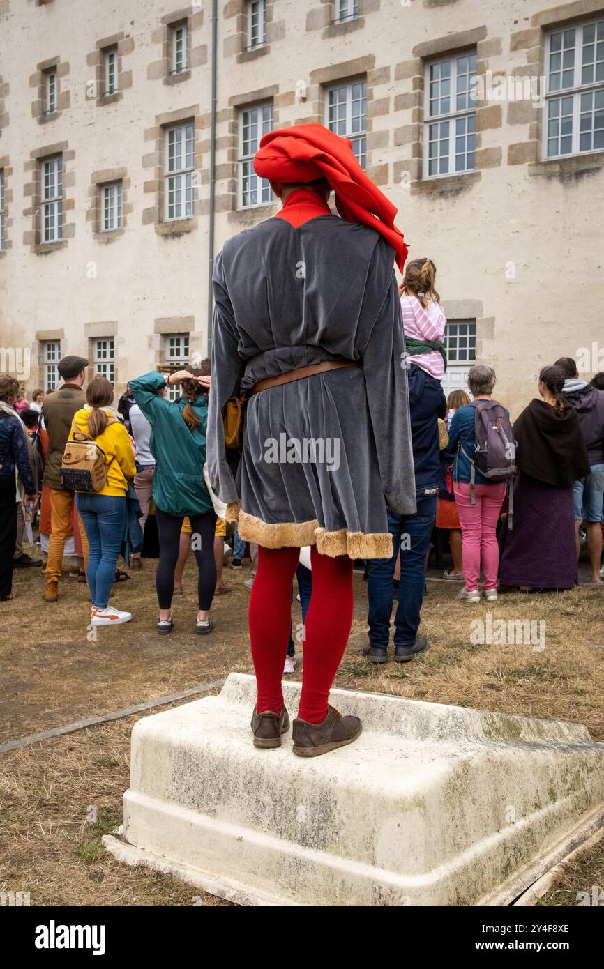 Un spectateur habillé en acrobate médiéval à la Fête des remparts dans la ville médiévale de Dinan dans la région côtes-d Armor de Bretagne en France Banque D'Images