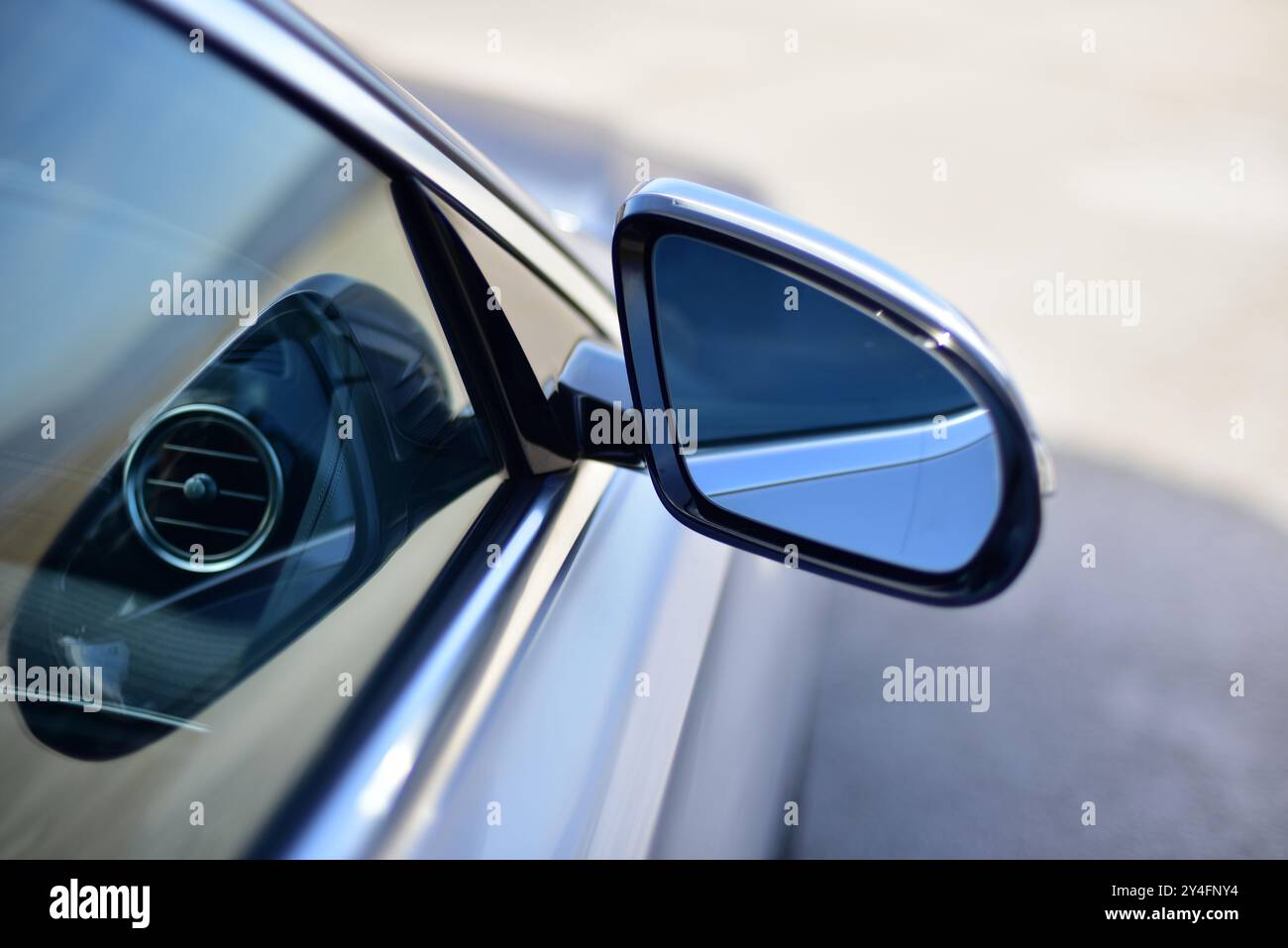 Rétroviseur latéral d'une voiture de tourisme avec éblouissement sur la vitre latérale. Banque D'Images