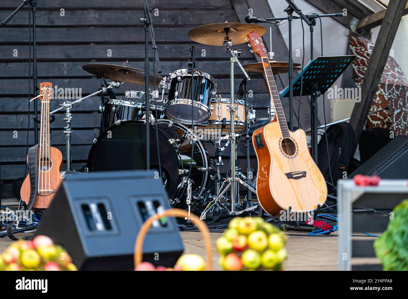Une scène est préparée avec des tambours et des guitares, en attendant le début d'un événement musical live. Banque D'Images